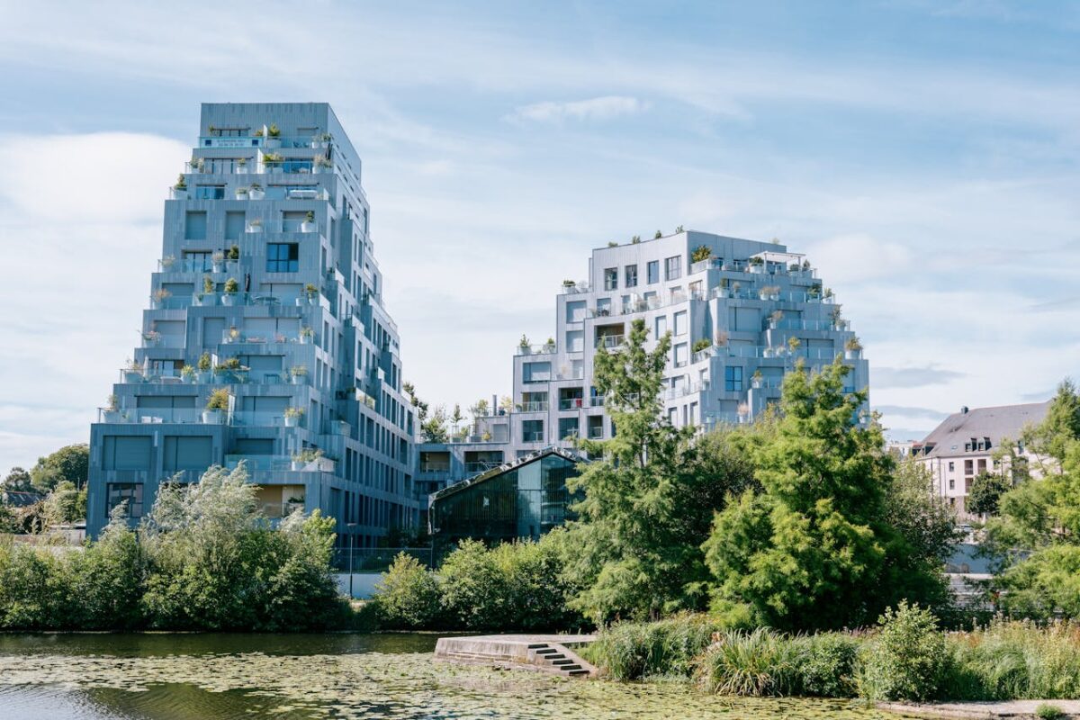 Elegant modern buildings near a river in Rennes, France, showcasing urban sophistication.