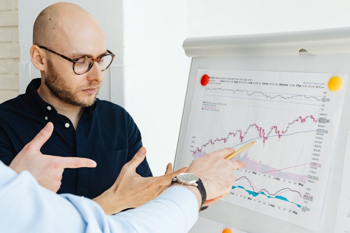 services-03 Business professionals discussing financial graphs on a flipchart during a daylight meeting.
